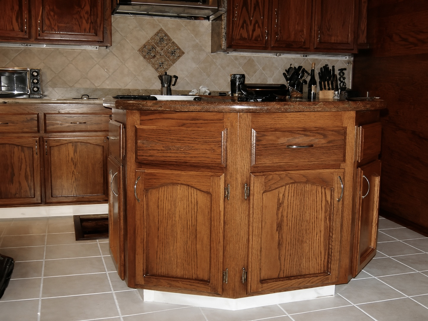 Solid oak kitchen island with raised-panel doors and granite top