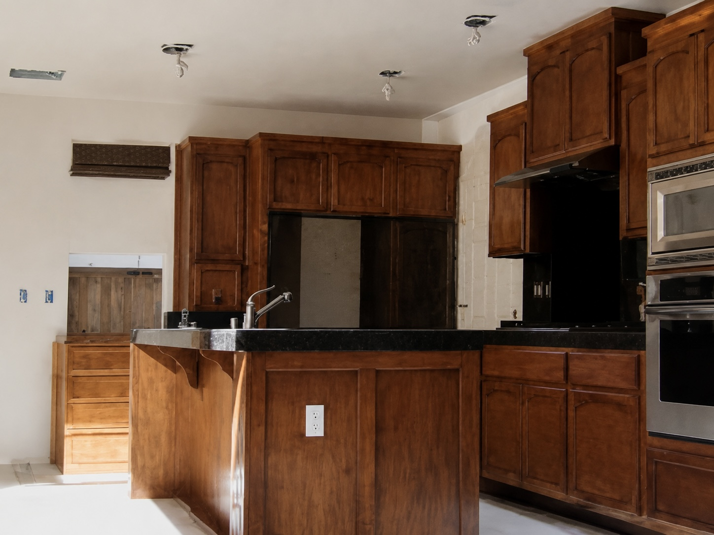 Warm walnut-stained kitchen with peninsula and double wall ovens